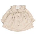 A beige long-sleeve baby dress with a ruffled Peter Pan collar and front button closure, laid flat on a white background.