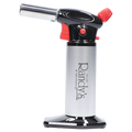 Side profile of Randy's Fahrenheit Butane Torch - Silver showing its chrome nozzle, black and red trigger head, and silver cylindrical body on a reflective black base