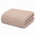Folded beige blanket on a white background