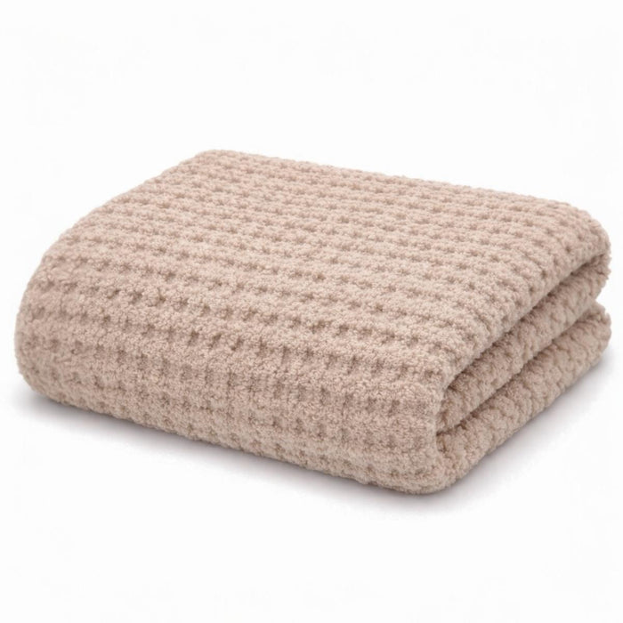 Folded beige blanket on a white background
